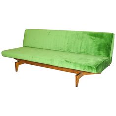 a green couch sitting on top of a wooden frame