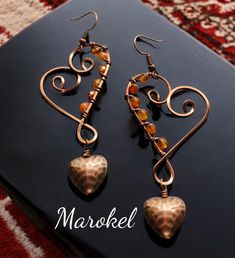 the earrings are made with copper, and have heart shaped beads hanging from it's earwires