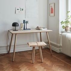 a desk with a lamp, books and other items on it next to a radiator