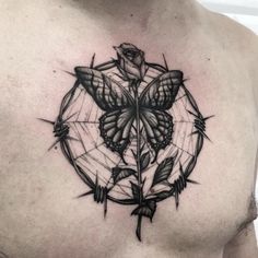 a man's chest with a black and white tattoo design on it, featuring a butterfly