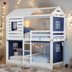 a white and blue bunk bed in a room with christmas lights on the wall behind it