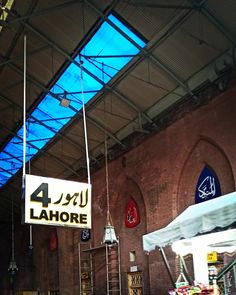 an indoor market with tables, chairs and umbrellas hanging from it's ceiling