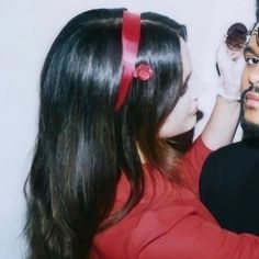 a man and woman are standing next to each other, one is holding a stuffed animal