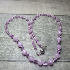 A subtle and sparkly purple necklace that is approx59cm (22in) long. At each end of the necklace five 4mm purple Angelite beads alternate with six 4x2mm unusual purple clear/opaque Czech Crystal rondelle beads. Then nine more of the Crystals alternate with nine 6mm Angelite beads, while in the middle of the necklace are eleven 6x4 Crystals alternating with ten 8mm Angelite beads. All these are separated by silver lined clear Glass seed beads. All the metal work is Stainless Steel including the magnetic clasp and the earwires on the free matching earrings. Necklace and earring come enclosed within a pink velvet bag. Angelite was first discovered in Peru in 1987. It is a peaceful stone infusing you with serenity and positivity. It supposedly enhances ones connections with Angels. This is a c Purple Polished Beads Crystal Necklace As Gift, Lavender Faceted Beads Crystal Necklace Gift, Adjustable Purple Necklace With Faceted Beads, Lavender Crystal Necklaces With Faceted Beads For Gifts, Lavender Faceted Beads Necklace For Gifts, Lavender Necklace With Faceted Beads Gift, Purple Adjustable Crystal Necklaces With Faceted Beads, Purple Amethyst Faceted Bead Crystal Necklaces, Purple Amethyst Crystal Necklaces With Faceted Beads