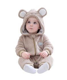 a baby in a bear costume sitting on the ground