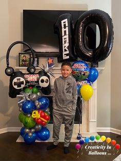 a young boy standing in front of balloons