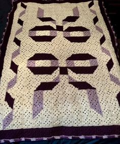 a crocheted blanket with black and white designs