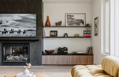 a living room filled with furniture and a fire place next to a wall mounted tv