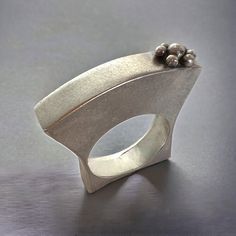 Graceful and elegant "hollow form" can be thought of as a small sculpture to wear! Amazingly comfortable as it follows the curvature of your fingers with its curvy contours. In sterling silver with a lovely satin brushed texture applied by hand, this is truly a beautiful piece of contemporary art to wear! This ring is 1/4" in width and measures 1 1/4" from top to bottom with approximately 3/8" of that sitting above the top of your finger. It measures to be approximately a 7 3/4 women's size ring Modern Silver Dome Ring For Wedding, Elegant Handmade Silver Dome Ring, Elegant Silver Dome Ring With Concave Shape, Formal Sculptural Silver Jewelry, Contemporary Silver Ring With Unique Design, Modern Silver Pearl Ring With Polished Finish, Contemporary Silver Rings For Wedding, Contemporary Sculptural Silver Jewelry, Modern Silver Pearl Open Ring