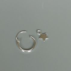 A PAIR of sterling silver hoops. Comes with a detachable tiny and delicate star charm. The charm is multipurpose and can be used with a neck or bracelet chain too. Dimension: Hoop- 12 x 1.5 mm Charm- 5 x 5 mm Drop length- 18 mm Price listed is for a PAIR of hoops. These earrings are made of 925 hypoallergenic sterling silver and comes with a 925 stamp. Can be packaged in a gift box. I can include a personal message from you if needed You are welcome to contact me at... bhavnakwintra1956@gmail.co Silver Star Huggie Earrings For Everyday, Silver Nickel-free Small Hoop Nose Rings, Small Hoop Sterling Silver Earrings With Star Charm, Silver Huggie Earrings With Charms In Small Hoop Shape, Silver Huggie Earrings With Star Charm For Gift, Silver Huggie Earrings With Star Charm As Gift, Sterling Silver Huggie Earrings With Star Charm For Everyday, Silver Small Hoop Earrings With Charms, Sterling Silver Hoop Earrings With Star Charm