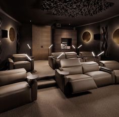 an empty theater with two recliners in the center and lights on the ceiling