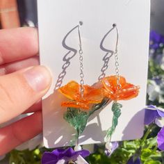 Elevate your style with our exquisite California Poppy Dangle Earrings, meticulously handcrafted using high-quality shrink plastic. These botanical-inspired earrings showcase the vibrant beauty of the iconic California poppy, capturing the essence of nature in a unique and wearable art form. The lightweight design ensures comfort, making them perfect for everyday wear or as a statement accessory for special occasions. Each pair is carefully crafted with love and attention to detail, making them a thoughtful and one-of-a-kind gift for nature enthusiasts. Embrace the charm of handcrafted jewelry and add a touch of floral elegance to your collection with these stunning California Poppy Dangle Earrings. 🌼✨ Handmade Flower Drop Earrings As Gift, Orange Flower-shaped Earrings For Gift, Handmade Flower Drop Earrings For Gift, Unique Flower Charm Dangle Earrings, Orange Flower Earrings For Gift, Unique Dangle Flower Charm Earrings, Unique Dangle Flower Earrings As A Gift, Handmade Orange Flower-shaped Jewelry, Handmade Flower Dangle Jewelry For Summer