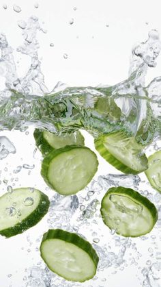 cucumber slices are falling into the water