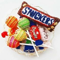 a bowl filled with assorted candies on top of a white table next to a candy bar