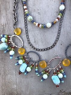 "One Of A Kind Necklace Set using Larimar Nuggets as the main gemstone with \"fringe\" of colorful semi-precious stones as Peridot, Kyanite, Natural Larimar, and Madeira Citrine. Accented with hand wired large Yellow Calcedony Heart Briolettes in between the Oxidized and Polished Sterling Links. There are also a few sparkly blue crystals in the fringe. The necklace is made in one piece. All the strands are connected. The Earrings have an Oxidized Sterling Link with a Larimar nugget accented with Dangle Earrings And Multi Necklace, Handmade Turquoise Briolette Jewelry, Bohemian Briolette Beads For Jewelry Making, Bohemian Briolette Gemstone Beads Jewelry, Bohemian Sterling Silver Briolette Jewelry, Artisan Briolette Jewelry With Natural Stones, Natural Briolette Gemstones In Bohemian Style, Bohemian Briolette Gemstones, Bohemian Blue Briolette Jewelry