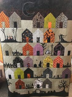 a quilted wall hanging with houses on it