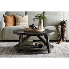 a living room with a couch, coffee table and pillows on the carpeted floor