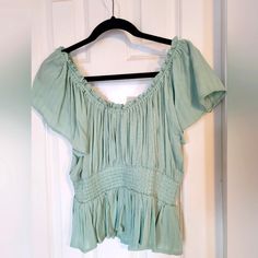 Elevate Your Style With This Beautiful Lane Tree Blouse, Perfect For Any Occasion. This Gorgeous Piece Features An Off-The-Shoulder Neckline, Flutter Sleeves, And Pleated Accents, Making It A Unique And Eye-Catching Addition To Your Wardrobe. The Mint Green Color Is Fresh And Versatile, While The Size Large Ensures A Comfortable And Flattering Fit. Ideal For Pairing With Jeans Or Dressing Up With A Skirt, This Blouse Is Sure To Become A Go-To Favorite. (Jeans In Pic Sold Separately) Cotton Short Sleeve Flowy Tops, Flowy Cotton Short Sleeve Tops, Flowy Cotton Tops With Short Sleeves, Green Flowy Short Sleeve Top, Green Smocked Top With Short Sleeves For Summer, Green Short Sleeve Top For Spring, Green Short Sleeve Peasant Top For Spring, Flowy Green Summer Top, Flowy Green Top For Summer