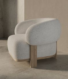 a white chair sitting on top of a cement floor next to a wall and window