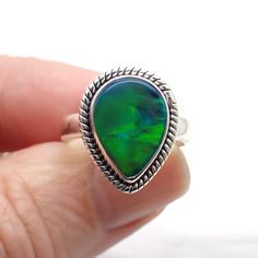 Aurora Opal is a man made stone consisting of Silica and Polymer rather than hydrated silica (natural opal). It comes in a variety of beautiful colors and almost glows with radiating color like the northern lights. Dimensions Size 7 | .7" long | .5" wide Green Opal Cabochon Ring, Unique Green Opal Ring, Green Opal Ring Gift, Green Opal Ring As A Gift, Green Opal Ring Spiritual Style, Green Opal Spiritual Ring, Spiritual Green Opal Ring Gift, Spiritual Green Opal Ring For Gift, Aurora Opal