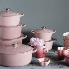 pink pots and pans are sitting on a table