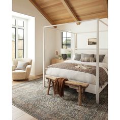 a bedroom with a canopy bed and white furniture in the room, along with a large window