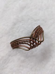 This is a simple and elegant vintage copper and brass cuff bracelet. The metals are braided together and twisted  into a wave-like shape that flows beautifully and looks nice on the wrist. Comfortable to wear, this bracelet will go well with different styles and occasions. This vintage bracelet is beautifully crafted with fine materials and has some weight to it. It is adjustable. See last picture for measurements. Unmarked, estate item, pre-owned in overall good condition. There is some patina Adjustable Wire Wrapped Bronze Cuff Bracelet, Hand Wrapped Bronze Metal Cuff Bracelet, Vintage Copper Cuff Bangle Bracelet, Vintage Copper Bangle Cuff Bracelet, Adjustable Bronze Copper Bangle, Brass Cuff Bracelet, Open Cuff Bracelet, Brass Cuff, Brass Bracelet