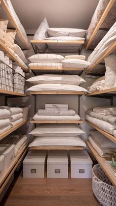 the shelves are filled with white linens and blankets