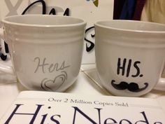 two mugs with mustache designs on them sitting next to a sign that says his needs