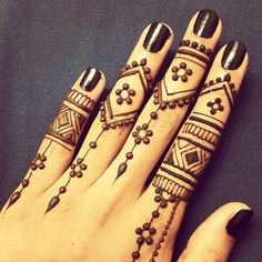 a woman's hand with tattoos on it and two rings around her fingers,