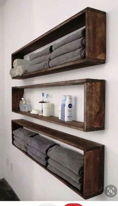 two wooden shelves with towels and soaps on them