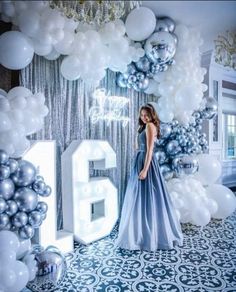 a woman standing in front of balloons with the number fifteen on it's wall