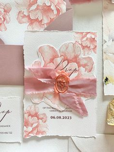 wedding stationery with pink and white flowers on it, including a wax stamper