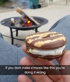 a person holding a chocolate covered donut with marshmallows on it and the words if you don't make s more like this you're doing it wrong