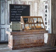 an old fashioned bakery display in front of a chalkboard