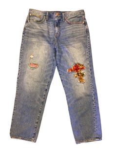 an old pair of jeans with flowers on them, and some holes in the back