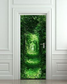 an open door with a green tunnel in the middle and trees on either side that leads to another room