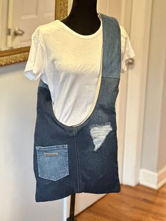 a white t - shirt and blue jean overalls on a mannequin stand