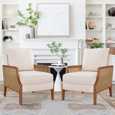 two chairs sitting next to each other on top of a rug in front of a fireplace