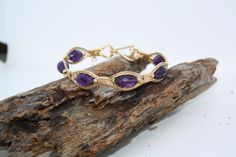 Lusciously purple Amethyst wrapped in Gorgeous 14kt Gold Filled wire with Gold filled beads on each side of the gemstones. If your a Feburary baby or just love the color purple this bracelet has it all. I also give you the option to have this bracelet made in 14kt Rose Gold fill or a Fine .935 Argentium Silver. Just choose your size and material option and I'll make this bracelet Just4u! Gold Bohemian Amethyst Beaded Bracelets, Bohemian Gold Amethyst Beaded Bracelets, Bohemian Gold Beaded Amethyst Bracelets, Wire Wrapped Amethyst Bracelets In Purple, Purple Wire Wrapped Bracelets As Gift, Purple Amethyst Wire Wrapped Bracelets, Wire Wrapped Purple Amethyst Bracelets, Wire Wrapped Amethyst Bracelet, Purple Wire Wrapped Bangle Jewelry