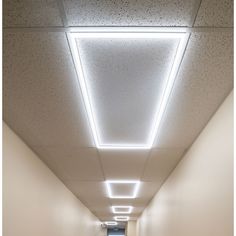 an empty hallway with lights on the ceiling and carpeted floor in front of it