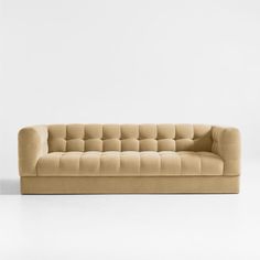 a beige couch sitting on top of a white floor