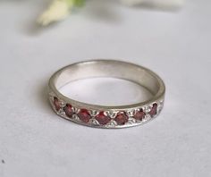 Handmade stackable and delicate silver Garnet ring for women, stoned with 7 red garnet gemstones.  This silver garnet half eternity ring is available in other gemstones as well including blue sapphire (see photo), onyx, ruby, peridot and clear zirconia.  Please choose your preferred gemstone on checkout. The red Garnet rings are designed in an antique vintage style and are beautiful for everyday wear, separately or stacked together for a mix of colors and beauty. Dimensions: The ring width is ab Vintage Ring Silver, Ruby Half Eternity Ring As Gift, Anniversary Stackable Garnet Gemstone Rings, Silver Ruby Half Eternity Promise Ring, Silver Ruby Promise Ring With Half Eternity Band, Silver Ruby Stackable Ring, Silver Ruby Ring Stackable, Silver Ruby Half Eternity Ring, Silver Half Eternity Birthstone Ring Gift