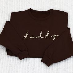 Celebrate parenthood with our daddy Sweatshirt. This cozy sweatshirt is perfect for dad or soon to be dads. Show your love and appreciation with this great gift idea. Get yours today! We primarily use unisex Jerzee Nublend sweatshirts. Matching embroidered mama and daddy sweatshirts mama versions available here Pre-shrunk Listing picture is chocolate sweatshirt with cream thread - ( matches closest to our sandstone sleepers 1x1 Ribbed collar, cuffs, and waistband with spandex Double-needle stitched collar ,armholes and waistband. Modern classic fit- Unisex T- not a fitted women style. See our current turnaround times here THIS ITEM IS EMBROIDERED DUE TO GLOBAL SUPPLY ISSUES ANOTHER SHIRT OF EQUAL QUALITY AND SIMILAR MEASUREMENTS WILL BE USED IN THE EVENT WE EXPIERENCE INVENTORY SHORTAGES. Father's Day Long Sleeve Relaxed Fit Sweatshirt, Father's Day Casual Sweatshirt With Name Print, Father's Day Cotton Sweatshirt With Name Print, Family Matching Crew Neck Sweatshirt For Father's Day, Family Cotton Sweatshirt With Letter Print, Family Cotton Crew Neck Sweatshirt, Father's Day Relaxed Fit Letter Print Sweatshirt, Father's Day Letter Print Relaxed Fit Sweatshirt, Father's Day Letter Print Sweatshirt