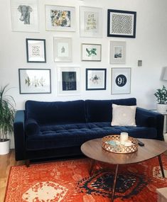 a living room filled with furniture and framed pictures on the wall above it's coffee table