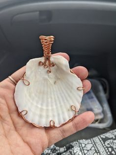 a person holding a shell with wire wrapped around it