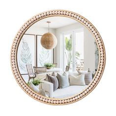 a living room filled with furniture and a round mirror