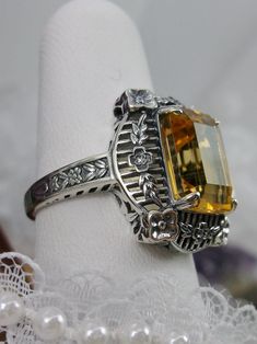 Natural Lemon-Yellow Citrine Sterling Silver RingPicture Frame Design#D227 Inspired by Victorian era designs, this is a lovely reproduction ring. This lovely filigree ring is handcrafted sterling silver. This gorgeous ring is set with a natural yellow citrine, which has a great shine and very good clarity. The emerald cut natural citrine gemstone is 12mm x 10mm. The ring measures 18mm North to South and 15mm East to West on the finger. The inside of the band is marked 925 for silver. Notice the Handmade Vintage Sterling Silver Filigree Ring, Vintage Sterling Silver Topaz Filigree Ring, Vintage Sterling Silver Topaz Ring With Filigree, Vintage Sterling Silver Topaz Ring, Handmade Victorian Sterling Silver Filigree Ring, Vintage Sterling Silver Intaglio Ring, Vintage Sterling Silver Topaz Ring With Intricate Design, Vintage Sterling Silver Topaz Collectible Ring, Handmade Vintage Topaz Ring For Anniversary