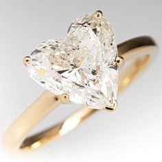 a heart - shaped diamond ring is shown in yellow gold and has a thin band