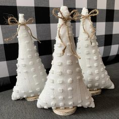 three small white christmas trees are sitting on a table